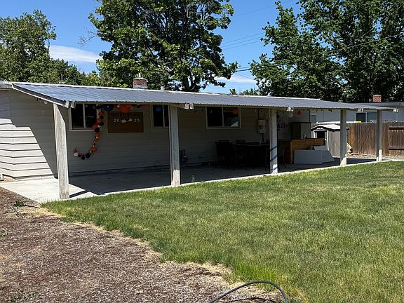 Large covered back patio in spacious backyard