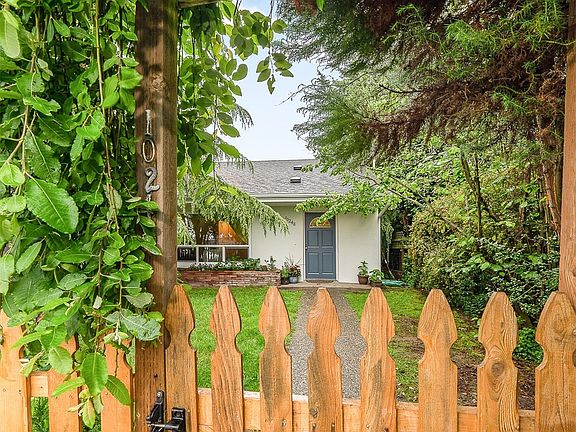Enter through a storybook picket fence to a peaceful, private front yard.