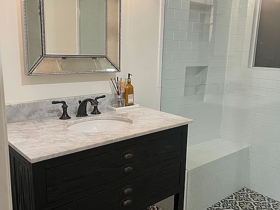 Bathroom with marble countertop and ceramic tiles