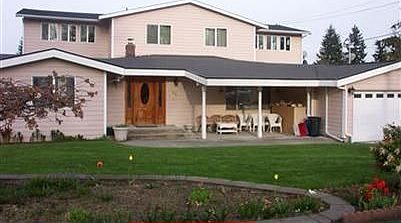 Front view of home w covered porch & manicured lawn