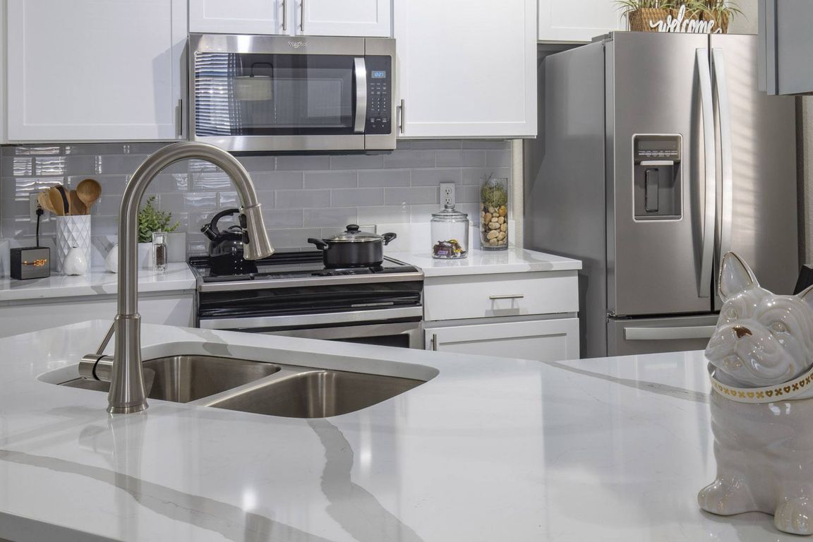 Modern Kitchen with Quartz Countertops, Fridge, and Tile Backsplash