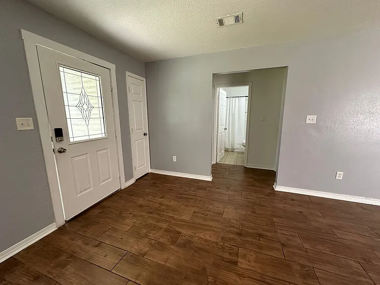 Opens into living room, access to shared bathroom.