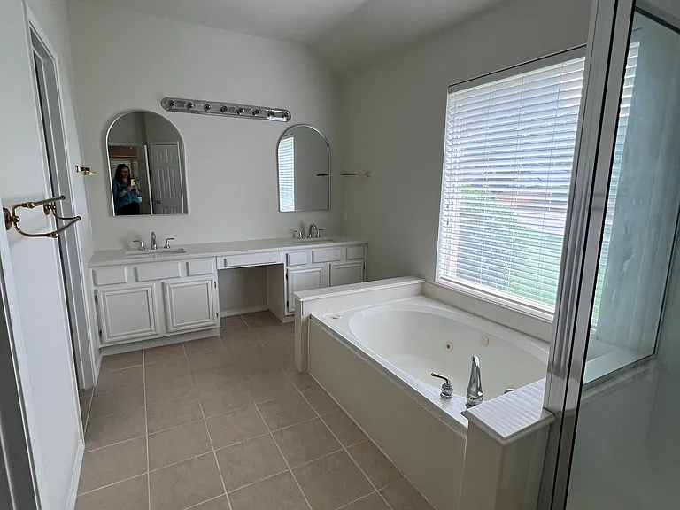 Master bath with glass shower, jet tub and private toilet.