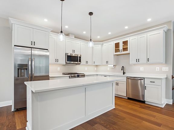 Brand new kitchen with quartz counters, gas stove, island bar