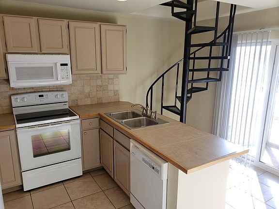 Kitchen and stairwell to upstairs. Large window/slider front entrance including glass greenhouse/mud room.