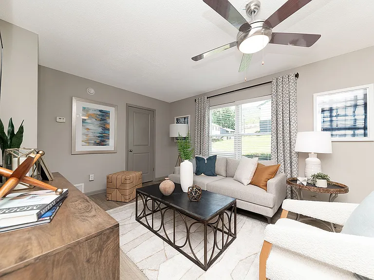 Spacious living room with hardwood-style flooring & ceiling fan