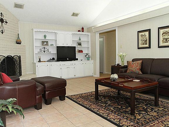 Back entrance leads into charming, comfortable family room with gas fireplace, built-in bookcases an