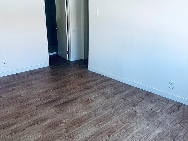 View from back corner of Master Bedroom, with Private Bathroom to the Right, Hallway access further right and Private Walk-in Closet out of Camera View to the Left