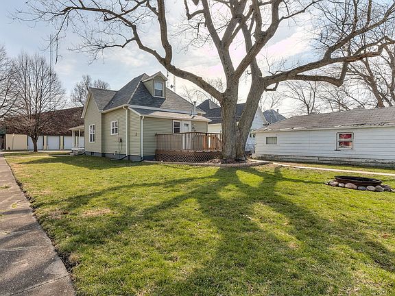 Back yard and fire pit area.  New sidewalk to garage.