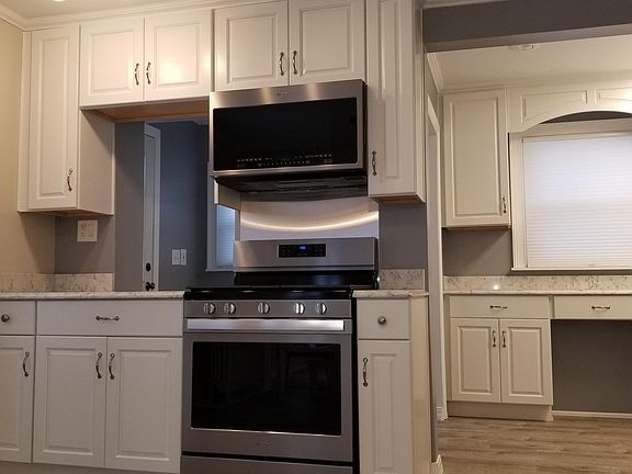 Multidimensional kitchen with new cabinetry, windows, and sparkly new appliances.
