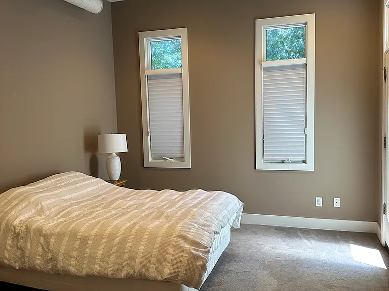 Bedroom upstairs with door to balcony .