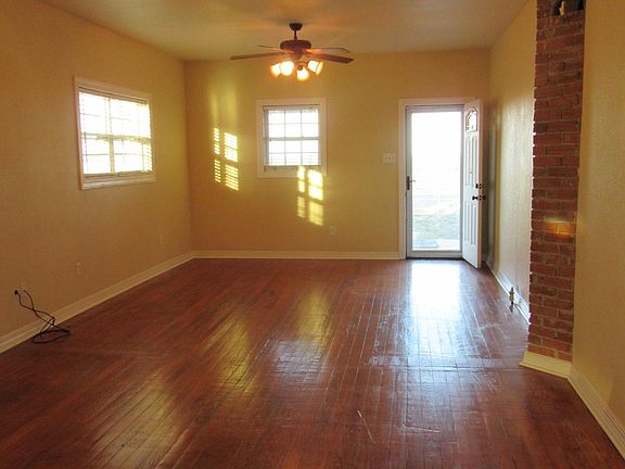 Living room with 9' ceilings and original hardwood floor. Doorway leads onto front porch.