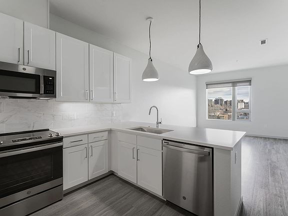 Open concept kitchen with marble backsplash and pendant lighting