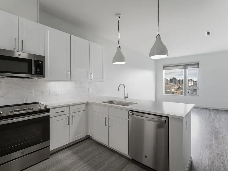 Open concept kitchen with marble backsplash and pendant lighting
