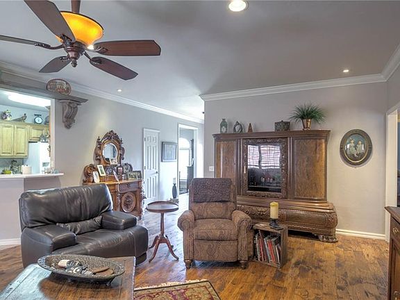 View of the living room looking back toward the front door. Kitchen is to the left, and the formal d