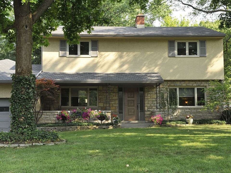 Charming stone and stucco home set among mature trees.