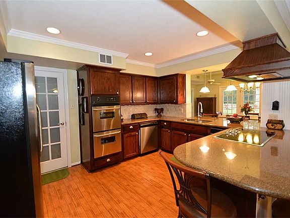 AMAZING OPEN KITCHEN. STAINLESS AND BLACK APPLIANCES, CUSTOM WOOD CABINETRY IN A NICE DARK COLOR. ALL ELECTRIC.
