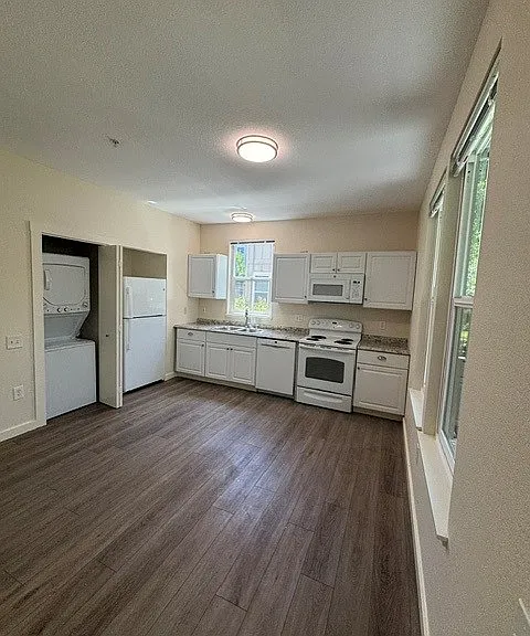 Kitchen includes eletric range, microwave, dishwasher, refrigerator/freezer, and stackable washer/dryer.