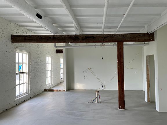 Exposed wooden bam and white painted bricks.