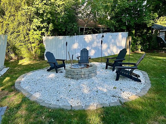 Buit-in firepit area complete with adirondak chairs and tiki torches for enjoying New England's beautiful fall evenings.