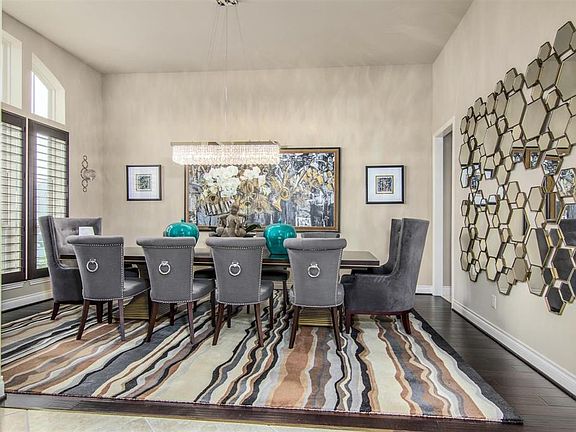 Spacious formal dining room with beautiful flooring and custom Plantation Shutters that lead to the Butler's Pantry.