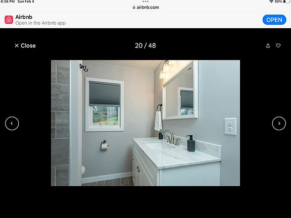 Bathroom off hallway includes tub with shower.