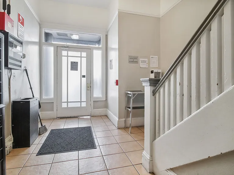 Apartment foyer with stylish decor, stairs, and mailboxes