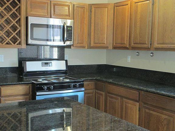 Granite countertops, wood cabinets, wine rack. Plenty of storage in the kitchen for all your kitchen needs.