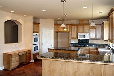 Large kitchen w/granite countertops, dual ovens, recessed lighting and desk.