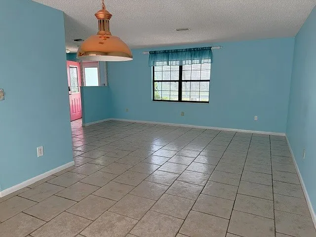 Dining area looking into Living room. Front door to the left. All rooms are either tiled or wood laminate floors, so no worry about stained carpets!