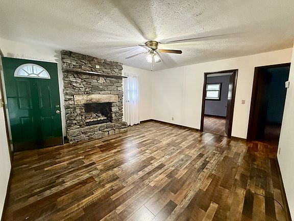 Den with beautiful stone fireplace work and gas logs.