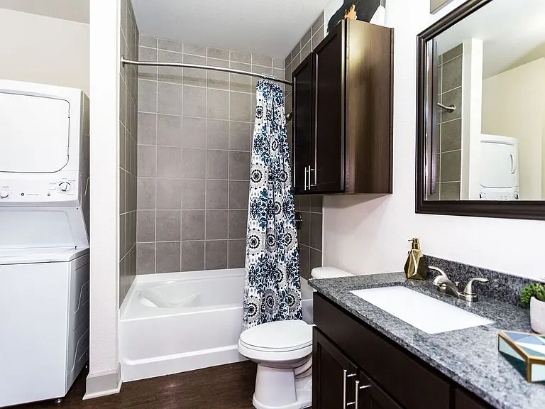 Classic Package bath with espresso cabinetry, speckled granite countertops, and hard surface flooring