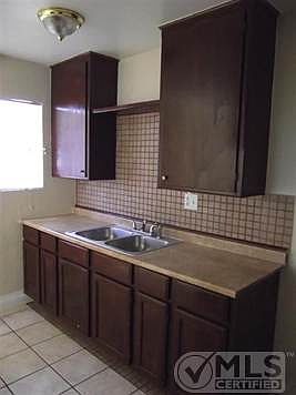 Nice cabinets, counters and sink with backsplash.