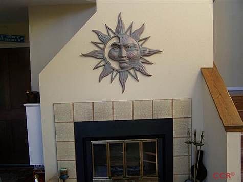Living Room with kitchen to left and stairs up to bedrooms on right.