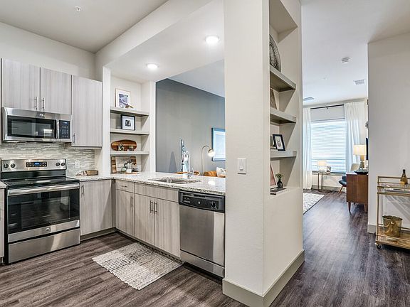 Gray finish package kitchen, living, and dining area with hard surface flooring throughout