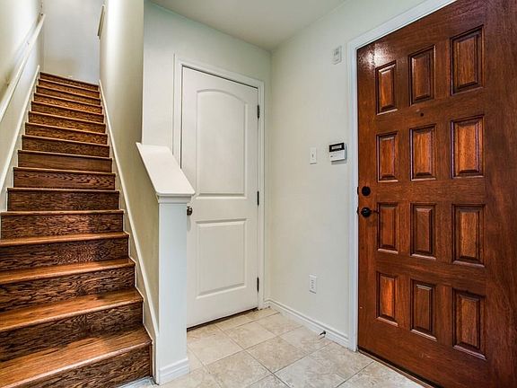 1st Floor Entry with view of the front door, door to garage, and wood stairs to main floor.