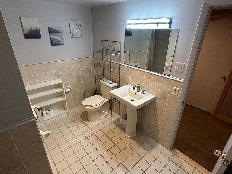 Bathroom shower is behind wall on right.