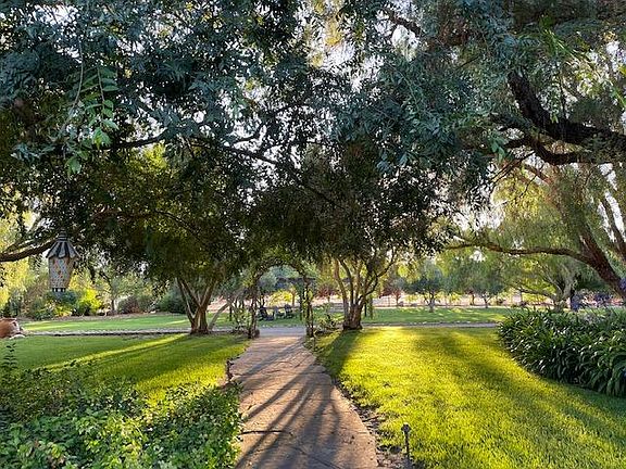 looking out front door to pergola w double chair swing, adirondack chairs