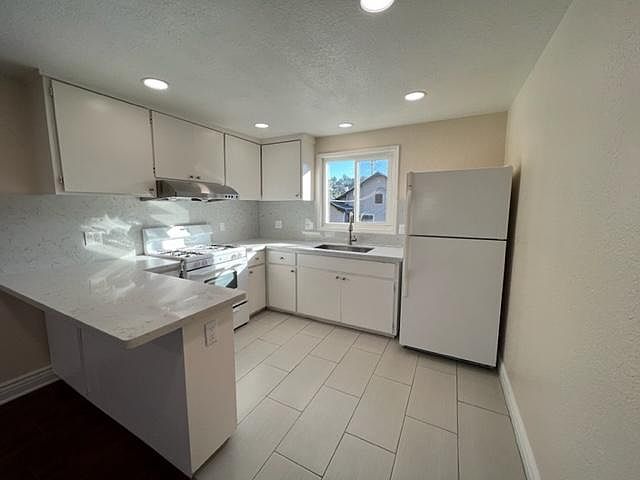 Kitchen with new recessed lights, Quartz Counter Tops and Backsplash and new range hood.