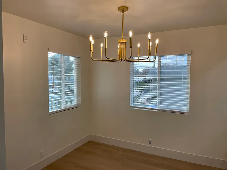 A modern multi-arm gold chandelier with dimmable lights