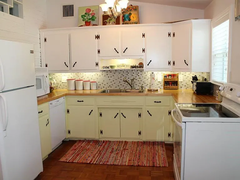 Kitchen looks into backyard and private pool. Parquet floor has been taken up to reveal terrazzo floor (which has been professionally refinished.