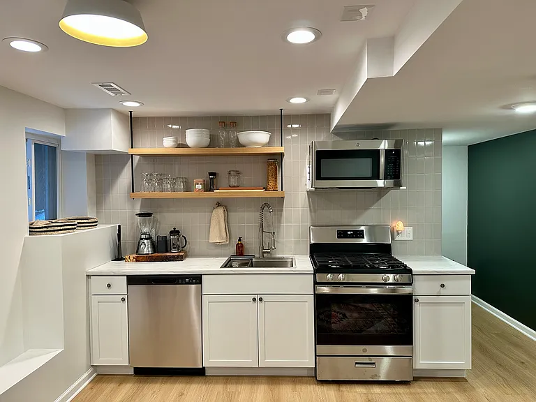 Fully functional modern kitchen with all new stainless steel appliances and a nice pop of green on the east wall.