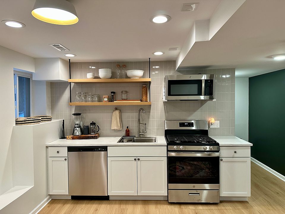 Fully functional modern kitchen with all new stainless steel appliances and a nice pop of green on the east wall.