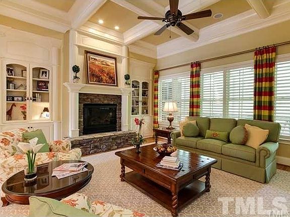 Incredible Great Room offers built-ins w/custom lighting, dramatic coffered ceiling, & plantation sh