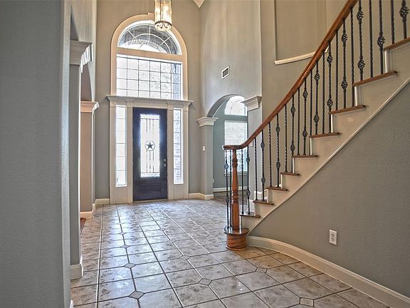 Stairs feature iron railings. Left side of picture is formal dining room
