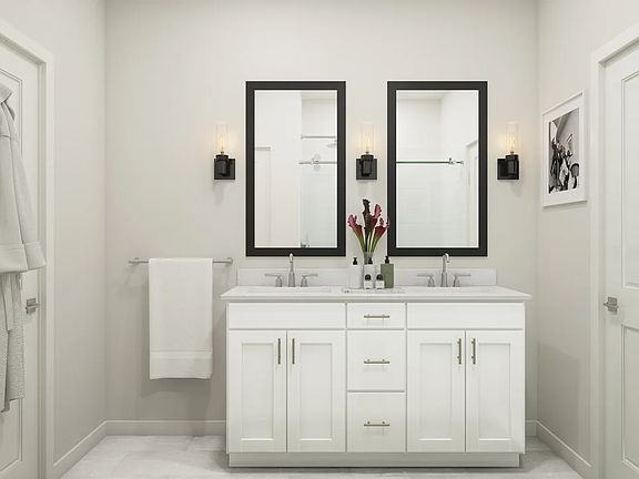 Primary bath with white vanity and black-framed mirrors