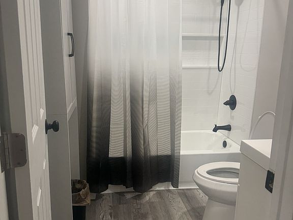 Hallway full bathroom with small linen cabinet on wall, tub shower combo