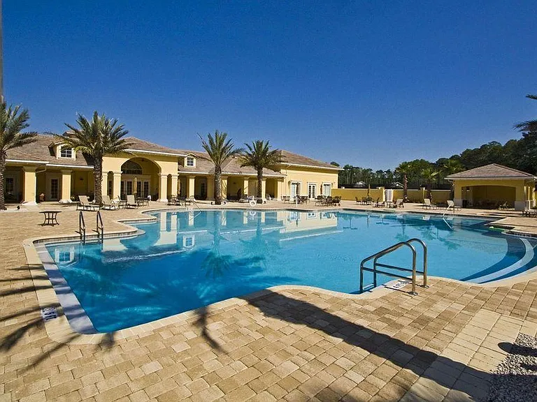 Outdoor pool with outdoor kitchen, large covered/shaded area in the background.