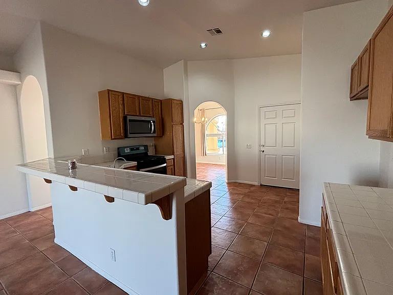 Open kitchen with breakfast bar, generous counter space, and convenient flow to the dining and living areas.