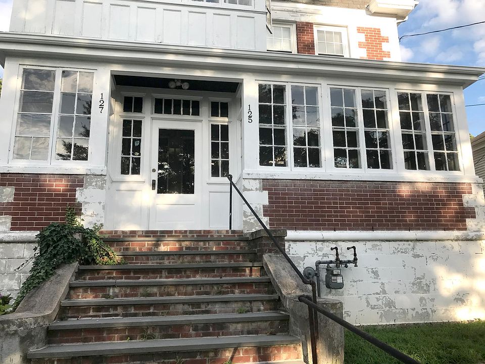 Front entrance to house. There are many stairs up from the sidewalk to the front door.